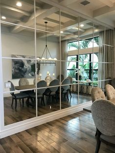 a dining room and living room are reflected in the glass wall