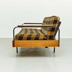 a chair that is sitting in the middle of a room with a plaid blanket on it