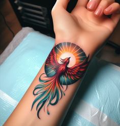 a woman's arm with a colorful bird tattoo on her left wrist and the sun in the background