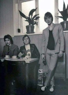 three young men are sitting at a table