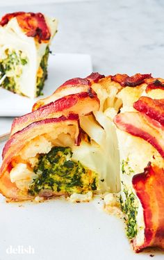 a bacon and broccoli pizza cut in half on a plate with a fork