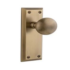 an antique brass door handle with a round knob