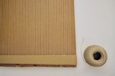 a spool of thread next to a piece of cardboard