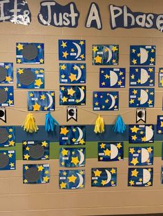 a bulletin board decorated with blue and yellow paper stars, crescents, and the words just a phase on it