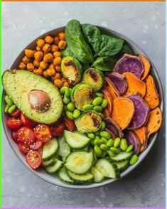 a bowl filled with lots of different types of vegetables next to chickpeas and avocado