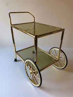 a glass and metal cart with wheels