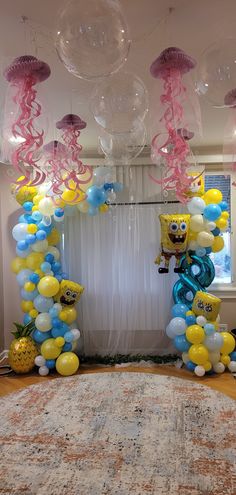 some balloons are hanging from the ceiling in front of a rug and table with an area rug