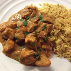 a white plate topped with rice and meat