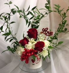 a vase filled with red and white flowers