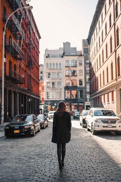 a woman is walking down the street in an old city