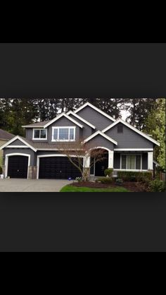 a large house with two garages in front of it