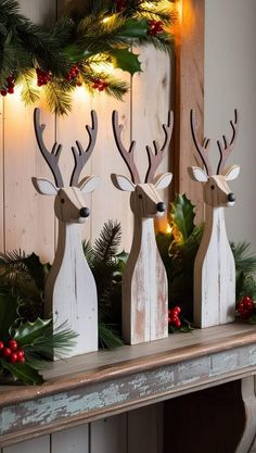 three wooden reindeer statues sitting on top of a mantle