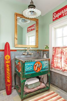 a bathroom with a sink, mirror and surfboard