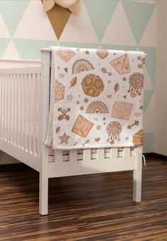 a baby crib with a blanket on top of it in front of a wall