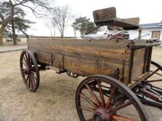 an old wooden cart with wheels on the ground