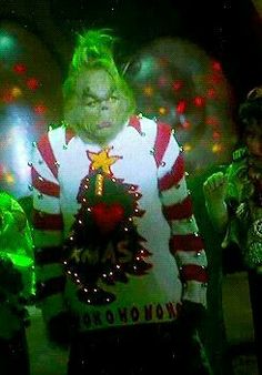 three people dressed up in ugly christmas sweaters and green hair, standing next to each other