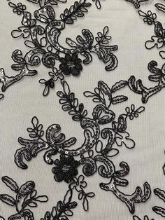 black lace with flowers and sequins on white fabric