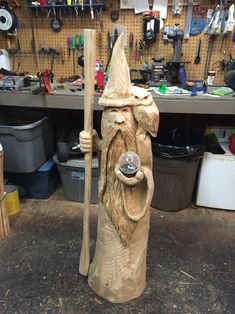 a wooden carving of a wizard holding a wand