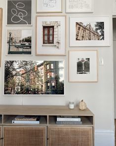 there are many pictures on the wall above the table and below it is an entertainment center