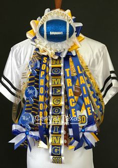 a football fan's jersey is adorned with blue, gold and white ribbons