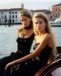 two beautiful young women sitting next to each other on a boat