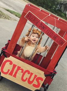 a baby in a wagon with a circus sign on it