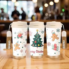 three coffee cups with christmas designs on them sitting on a table in front of a bar