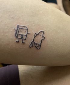 a person with a small tattoo on their arm that has an image of a bear and a dog