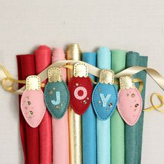 a row of colorful crepe paper tubes with the word joy hanging from them