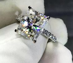 a diamond ring is sitting on top of a white glove