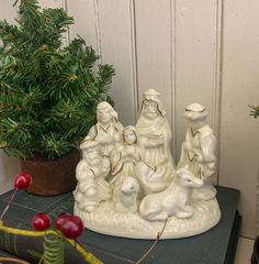 a small christmas tree sitting on top of a table next to a figurine