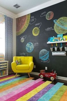 a child's room with a chalkboard wall and colorful rugs on the floor