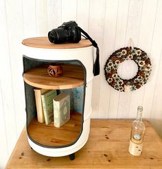 a camera sitting on top of a wooden table next to a book shelf with books