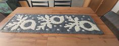 a wooden table topped with a blue rug covered in snowflakes and letters on it