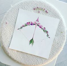 a piece of paper with flowers on it sitting on top of a white tablecloth