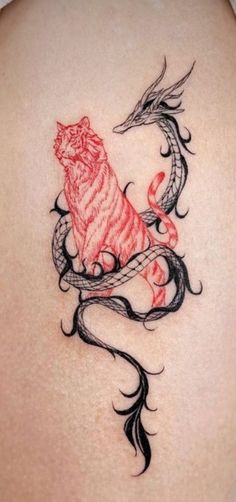 a woman's back tattoo with a dragon and tiger on it