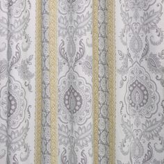 a curtain with an ornate design in grey and yellow colors, hanging on a wall