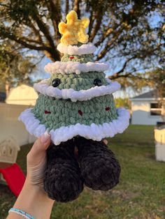 someone is holding up a crocheted christmas tree