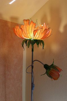 a lamp that is sitting on top of a table next to a vase with flowers in it