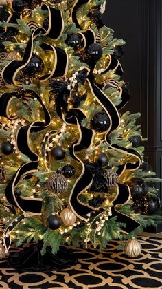 a black and gold christmas tree decorated with ornaments