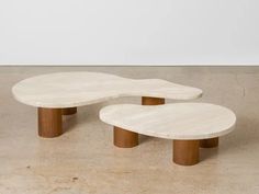 two white marble coffee tables sitting on top of a cement floor