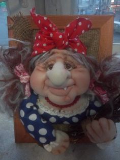 a close up of a trolly doll on a chair with a red and white polka dot headband