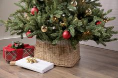 a christmas tree in a basket with presents under it