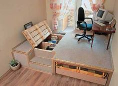 a computer desk sitting on top of a wooden floor next to a chair and window