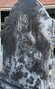 an old tombstone with trees on it in front of a brick building