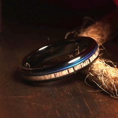 two wedding rings sitting on top of a wooden table next to some twined rope