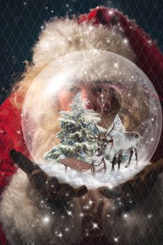 a man in a santa suit holding a snow globe