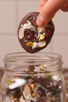 a hand is picking up some food from a jar