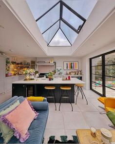 an open kitchen and living room with skylights