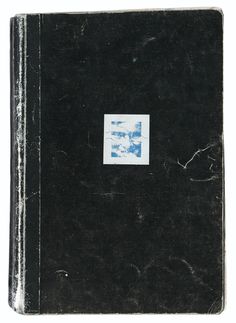 an old black book with blue and white designs on the front cover, sitting open